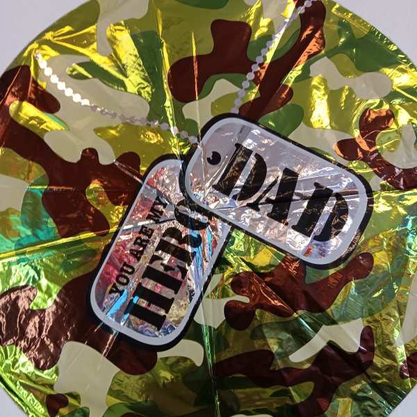 Camouflage-patterned round foil balloon with a "Dad" label