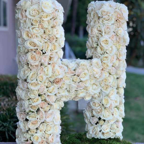 Large floral letter H covered in cream roses