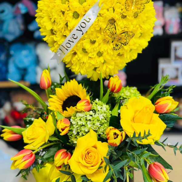 Yellow flower arrangement with roses, tulips, and a heart topper