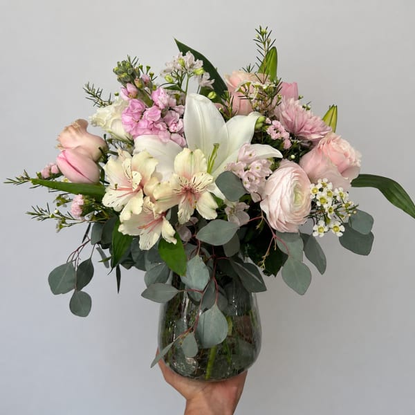 Pink and white mixed flower arrangement in a glass vase