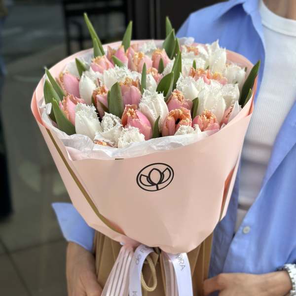 Bouquet of pink and white tulips wrapped in pale pink paper