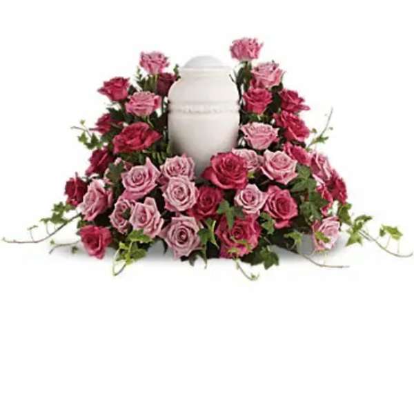 Pink and red roses arranged around a white urn