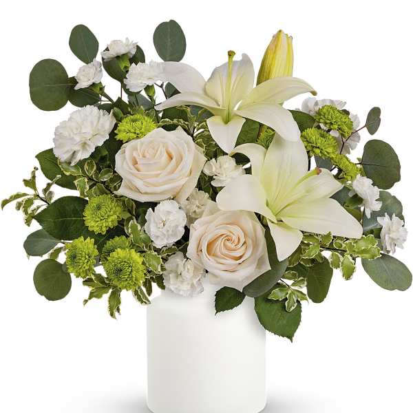 White lilies and pale roses in a white vase with green accents