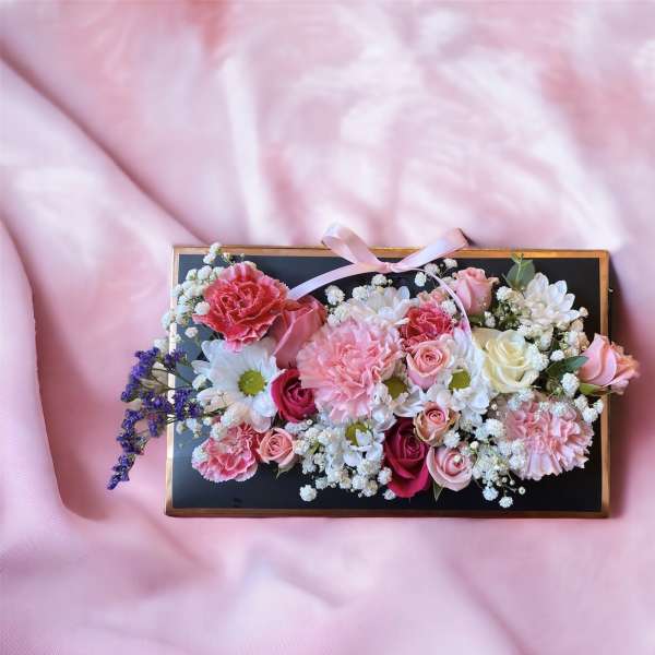 Rectangular floral box with pink and white flowers and a ribbon bow