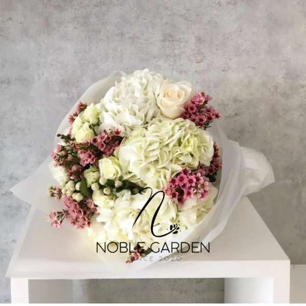 Bouquet of white hydrangeas, cream roses, and pink filler flowers