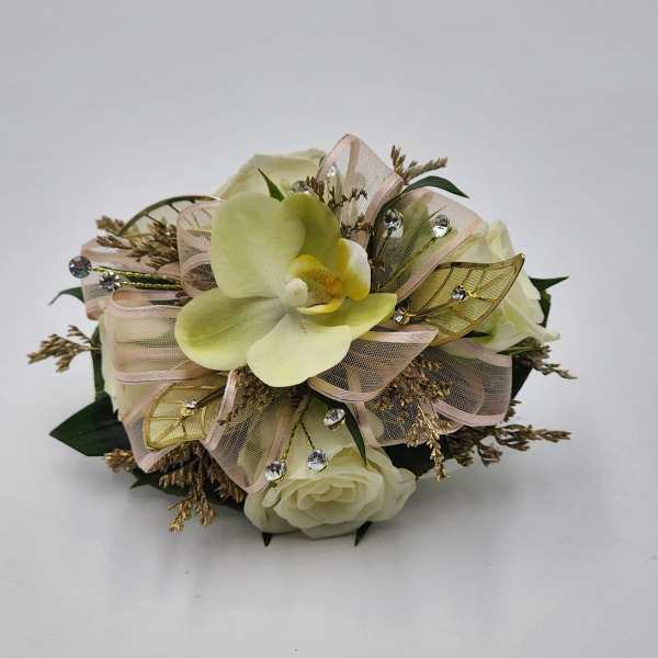 Cream orchid and rose arrangement with ribbon and jeweled accents