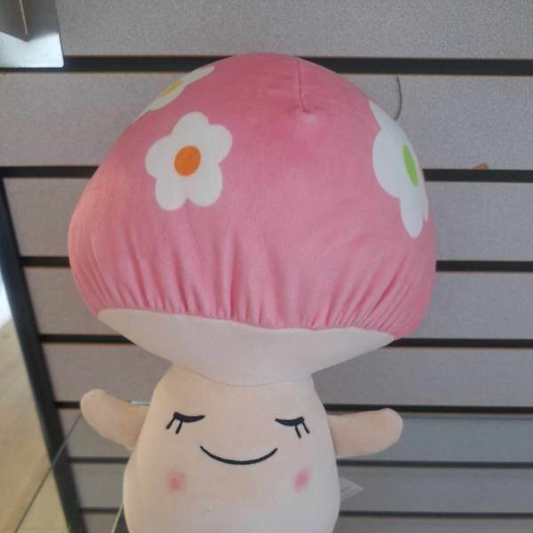 Plush pink-capped mushroom toy with a smiling face and flower spots on top.