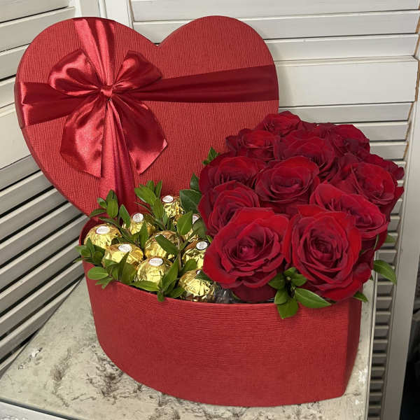 Heart-shaped red gift box with red roses and gold-wrapped chocolates