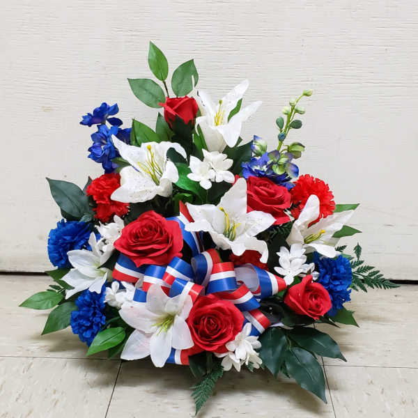 Red, white, and blue silk arrangement with roses, lilies, and carnations with patriotic ribbon in a low container