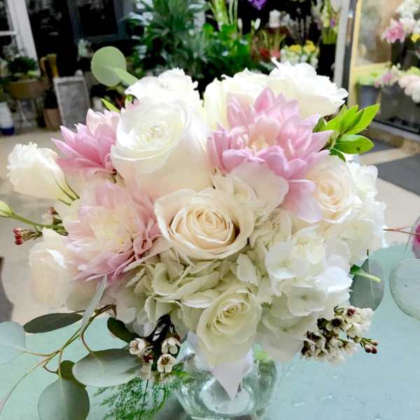 Pink and white bouquet of roses and hydrangeas in a clear glass vase