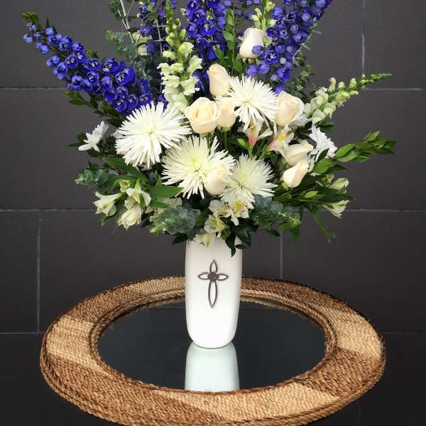 Tall white vase arrangement with blue and white flowers