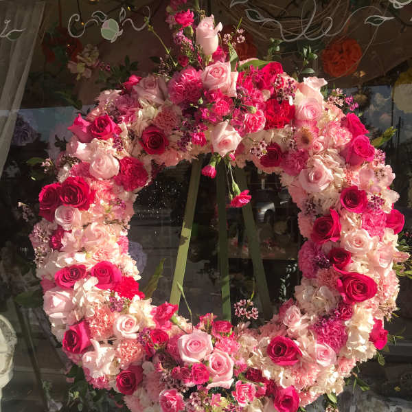 Large pink and white floral wreath on an easel