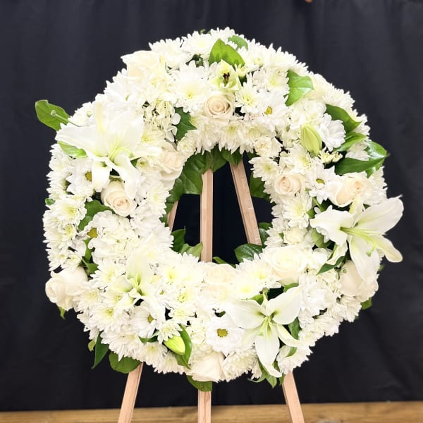 White floral wreath on a wooden easel