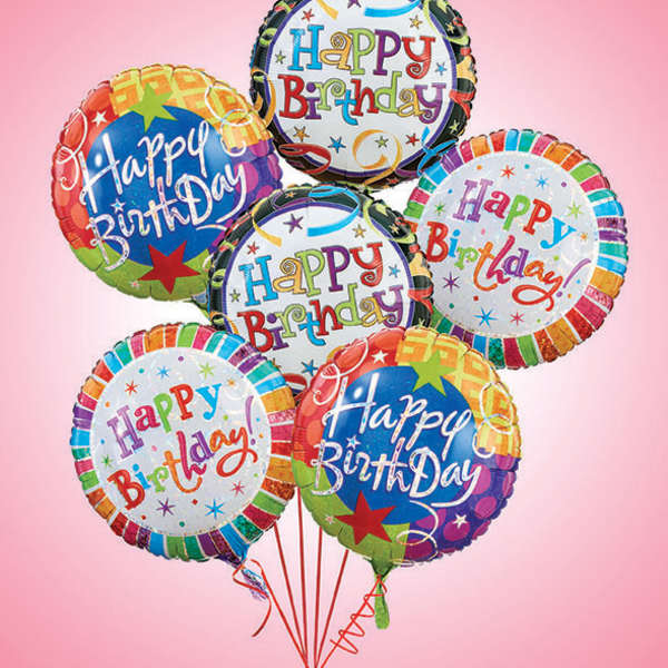 Cluster of colorful Happy Birthday balloons on a pink background