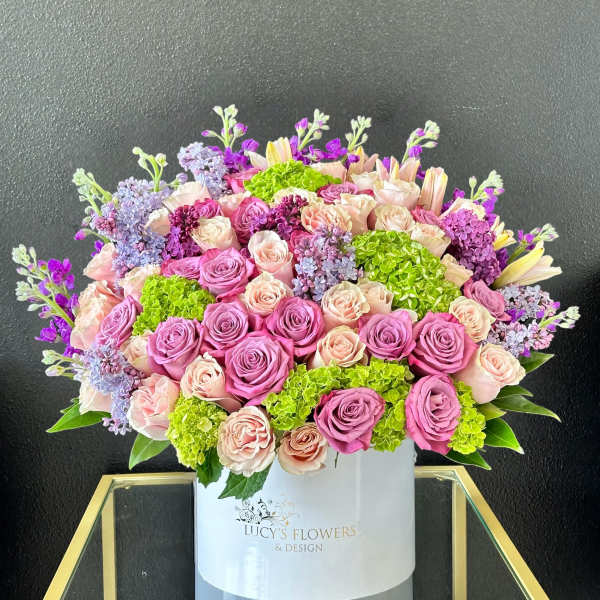 Large bouquet of pink and peach roses in a white box