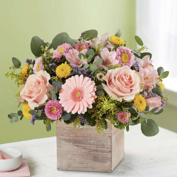 Pink roses and mixed daisies in a wooden box