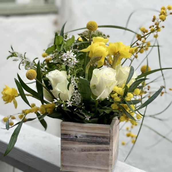 Yellow and white floral arrangement in a wooden box