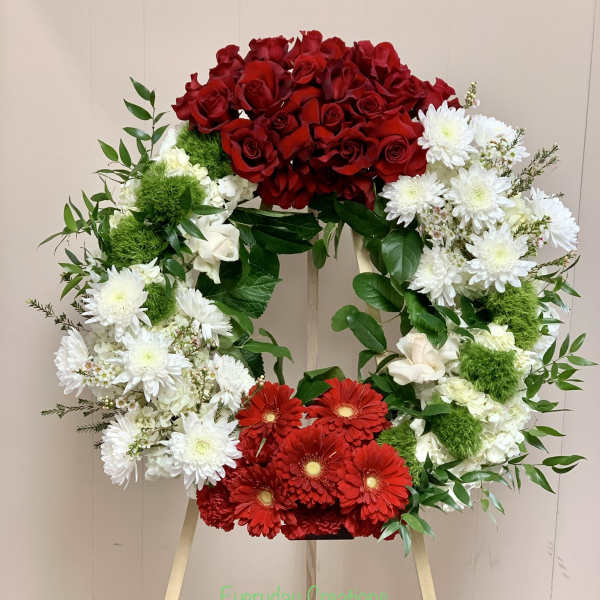 Heart-shaped floral wreath with red roses, white daisies, and red gerberas