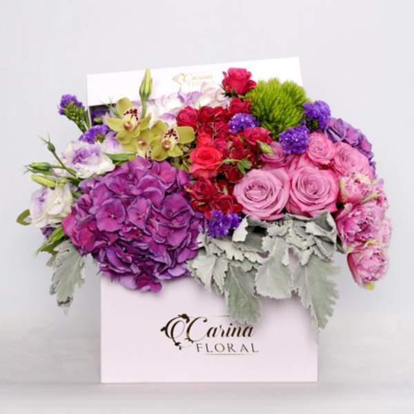 Colorful bouquet in a white gift box with pink, purple, and red flowers