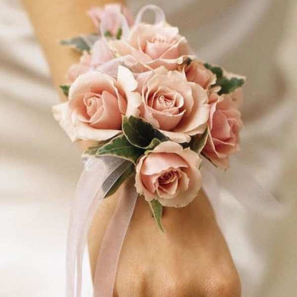 Pink rose wrist corsage with ribbon on a wrist