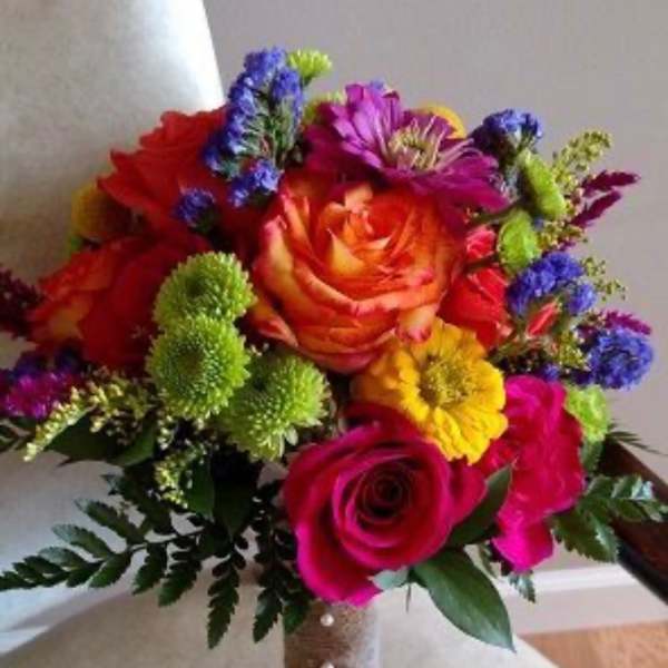 Colorful bouquet of roses and mixed flowers with a wrapped handle