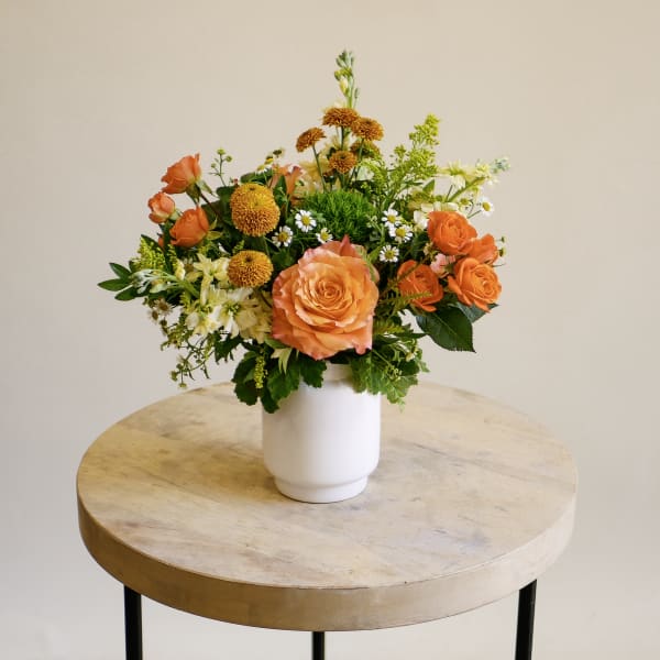 Orange and white mixed bouquet in a white vase