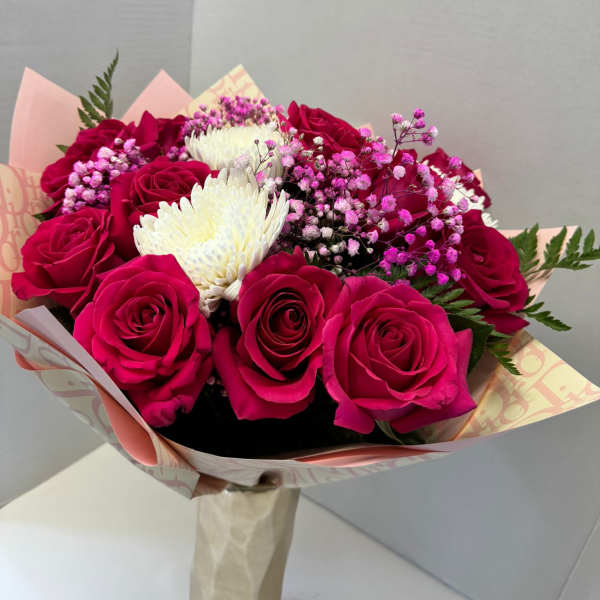 Bouquet of hot pink roses with white chrysanthemum blooms and pink baby's breath