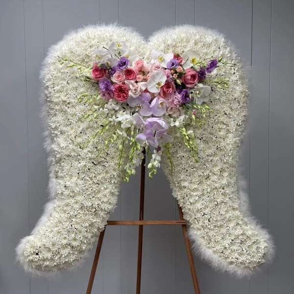 Large white floral standing spray with pink and purple roses and orchids