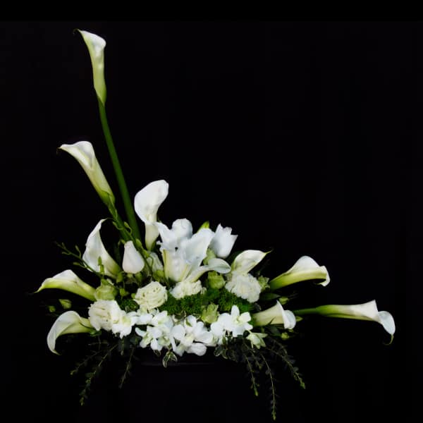 White calla lilies and orchids arranged in a low centerpiece