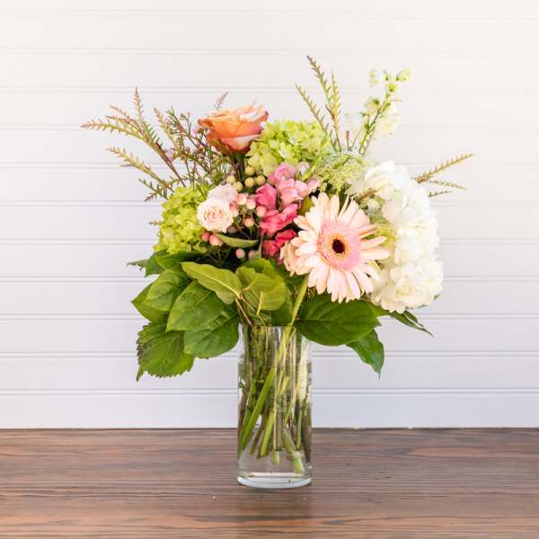 Mixed bouquet in a clear glass vase with pink and white blooms