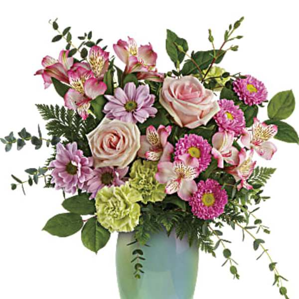 Mixed pink and lavender flowers in a green vase