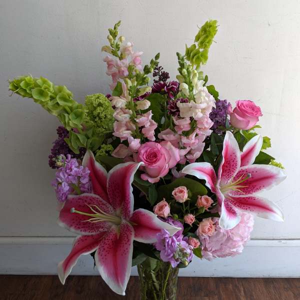 Pink lilies and roses in a clear glass vase