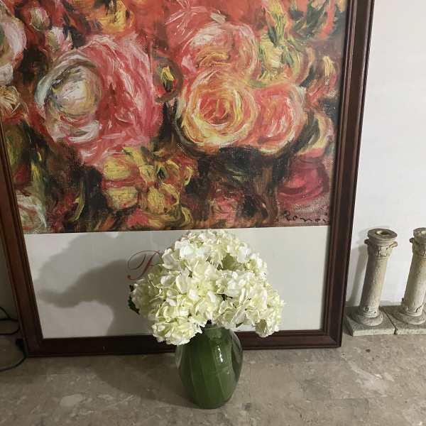 White hydrangea arrangement in a green vase