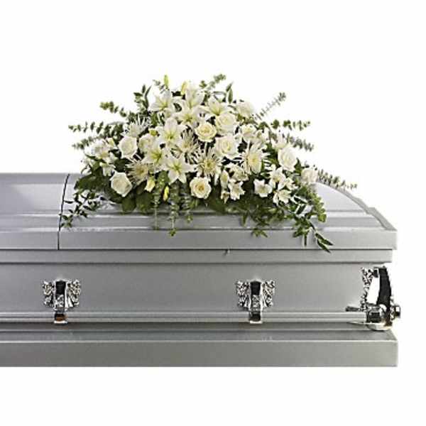 White floral casket spray on a gray casket