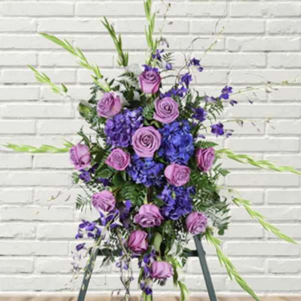 Tall purple and lavender floral arrangement with roses and blue blooms