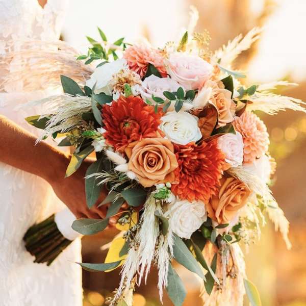 Bride holding a bouquet of peach, pink, and white flowers