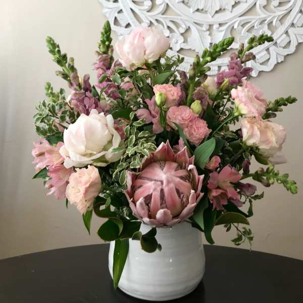 Pink and white mixed flower arrangement in a white vase