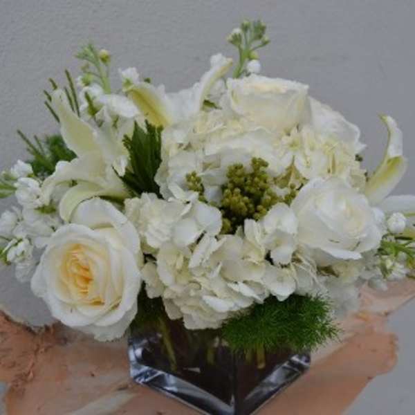 White floral bouquet with roses and lilies in a clear vase