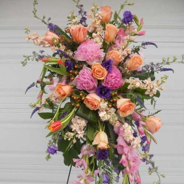Tall standing floral spray with peach, pink, and purple flowers