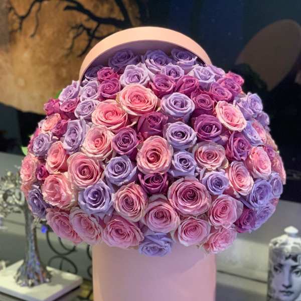 Round bouquet of pink and lavender roses in a pink hat box