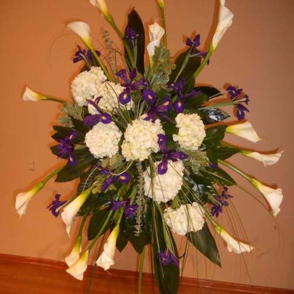 Tall floral standing spray with white calla lilies and purple flowers