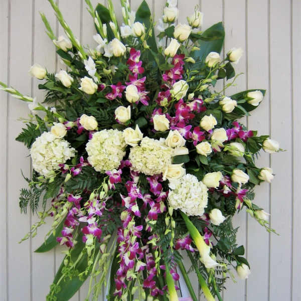 Large standing sympathy spray with white roses, orchids, and calla lilies