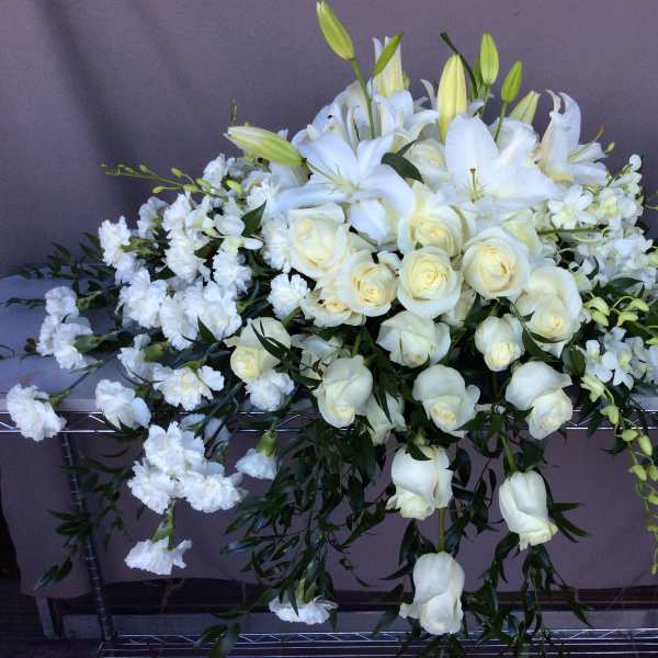 White roses and lilies arranged in a large spray
