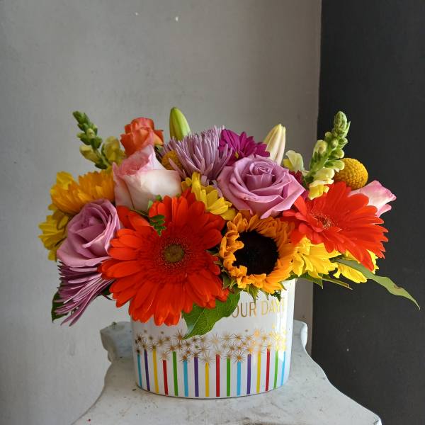 Colorful mixed bouquet in a white decorative container