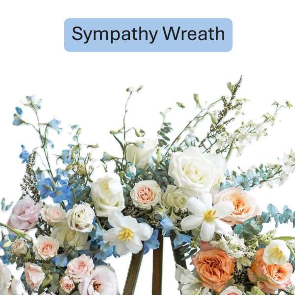 Sympathy wreath with white, peach, and blue flowers