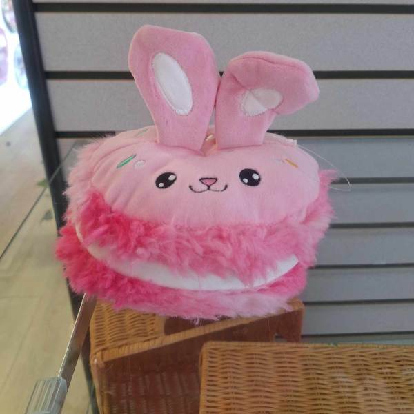 Pink plush bunny toy with tall ears and a smiling face