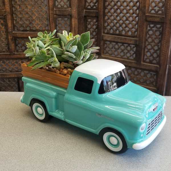 Succulents arranged in a turquoise ceramic truck planter