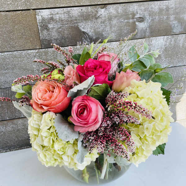Bouquet of pink roses and pale hydrangeas in a glass vase