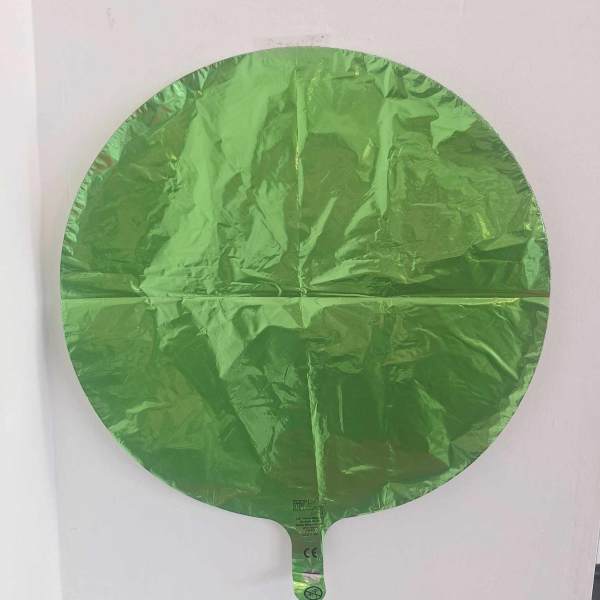 Round green foil balloon against a white background