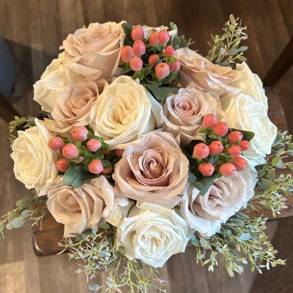 Bouquet of blush and white roses with pink berry accents